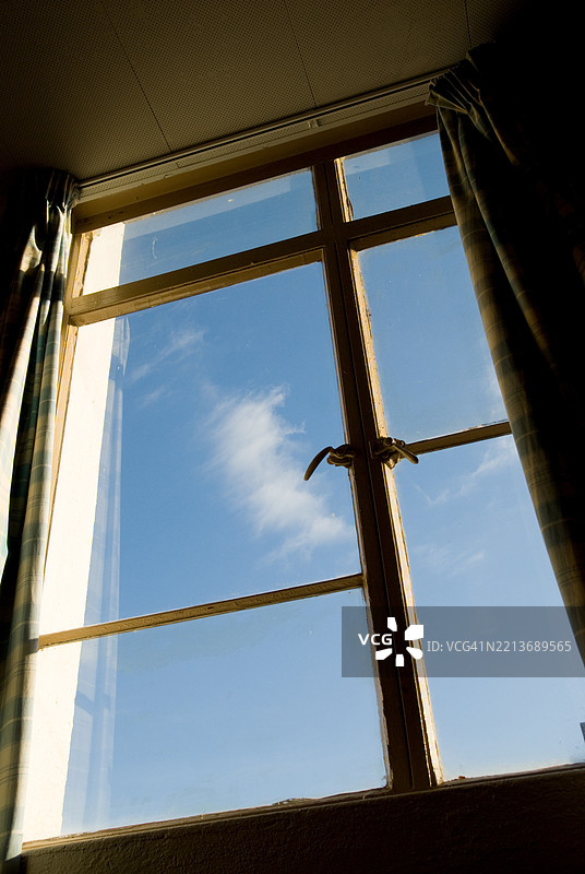 卧室窗外的低角度视图，蓝天和白云。图片素材