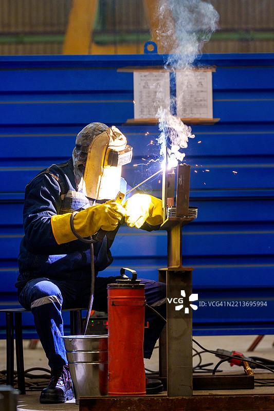 工厂车间内的工业焊工正在使用TIG焊枪焊接管道图片素材