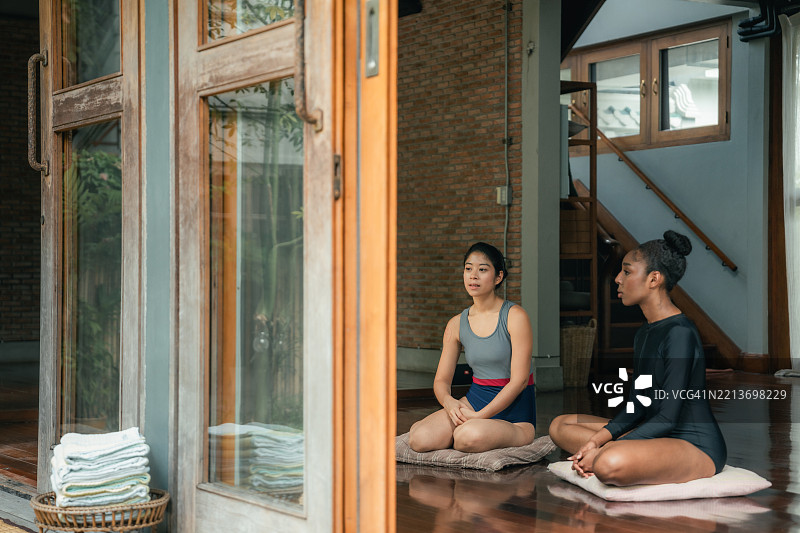 女人认真倾听冥想指导老师的话语，让指导平静她的心灵，带来更深层次的宁静感。图片素材