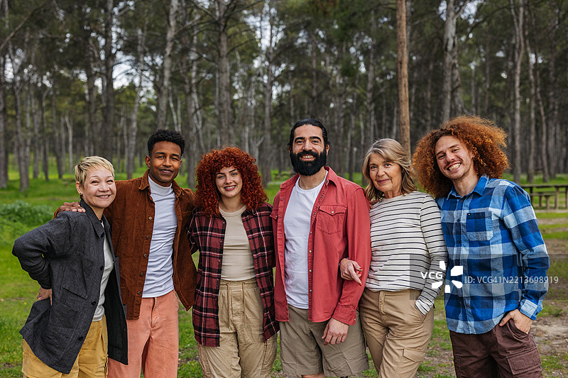 一群多元化的朋友在树林中微笑在一起图片素材