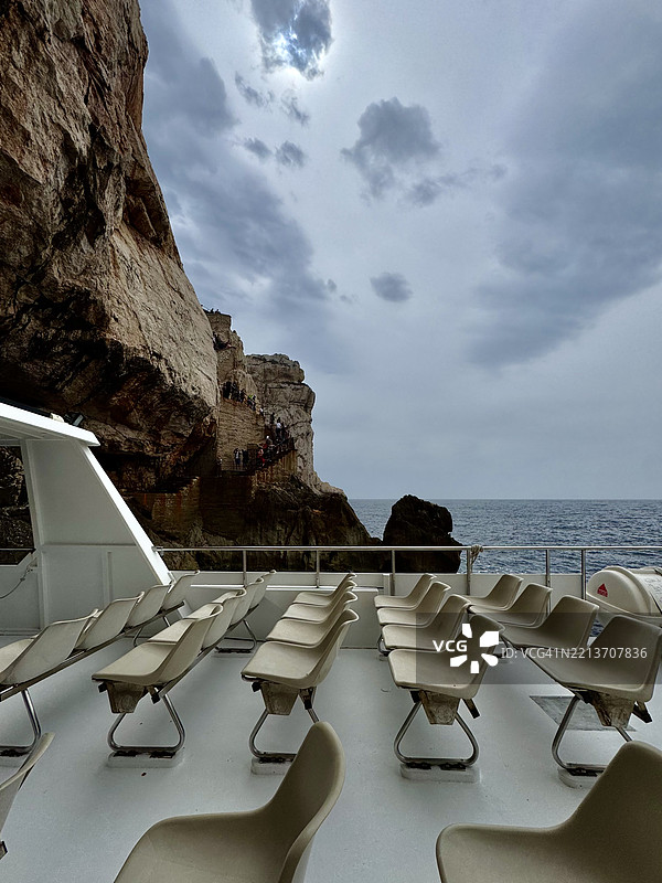 海岸探险：船甲板视角下的崎岖悬崖与历史阶梯图片素材