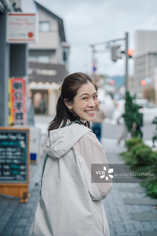 在日本松本，一位亚洲女性网红在户外与她的设备互动，记录她的日常旅行生活。图片素材