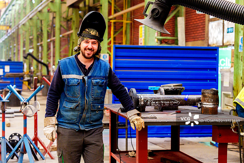 工厂车间内的工业焊工正在使用TIG焊枪焊接管道图片素材