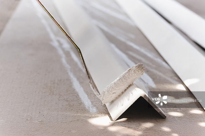 用滚筒刷给金属角落上漆图片素材