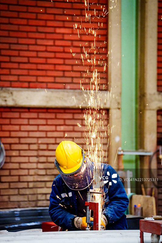 工厂车间内，工业焊工正在使用TIG焊枪焊接管道图片素材