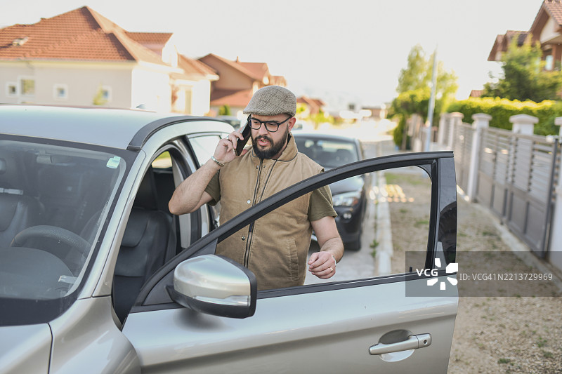 男人在下车时打电话并关上车门图片素材