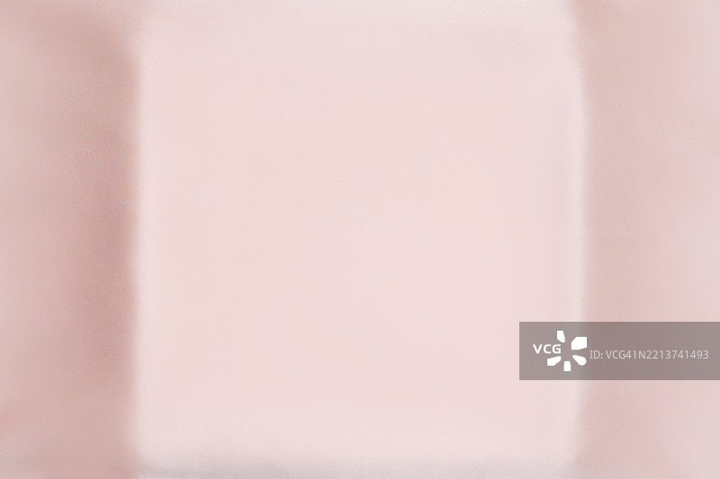 柔和粉色丝绸面料与讲台平铺。柔和的质感和轻微的高光。图片素材