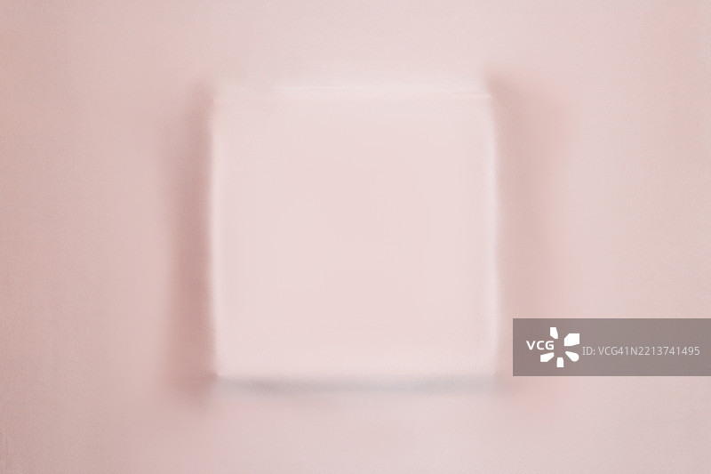 柔和粉色丝绸面料与讲台平铺。柔和的质感和轻微的高光。图片素材