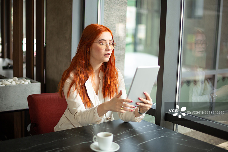 专注的女商人在现代咖啡馆使用平板电脑图片素材