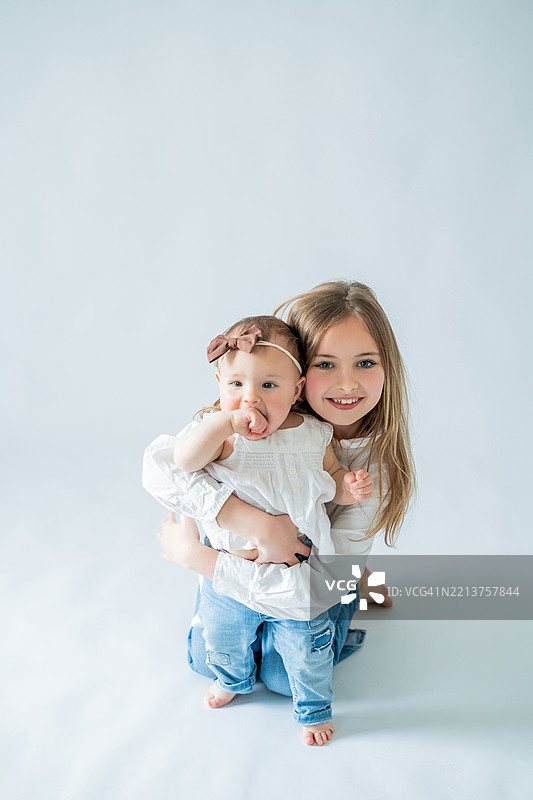 可爱的孩子们在一起玩耍。9岁的姐姐和她的小妹妹玩得很开心。图片素材