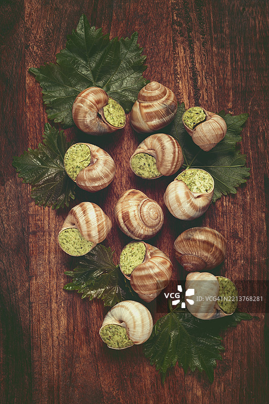 布根地酿蜗牛，俯视图，配有葡萄叶，法式料理，无人景象图片素材