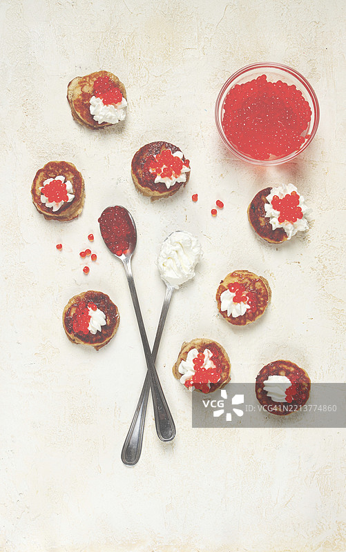 德米多夫薄饼，迷你煎饼，配酸奶油和红鱼子酱，法式薄饼。自制，无人。图片素材