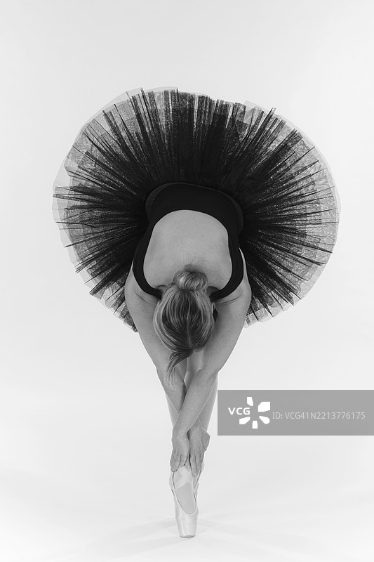 从上方俯瞰一位穿着黑色芭蕾舞裙的芭蕾舞者，优雅的姿势，艺术黑白照片，工作室摄影，德国巴伐利亚州安特阿尔高的明德尔海姆，欧洲图片素材