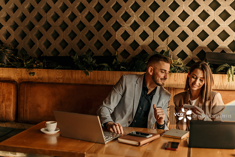 商业伙伴在咖啡馆会议中查看名片图片素材