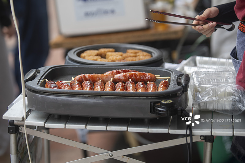 第50届野外大道艺美食摊位上电热板上烹饪的串烧香肠图片素材
