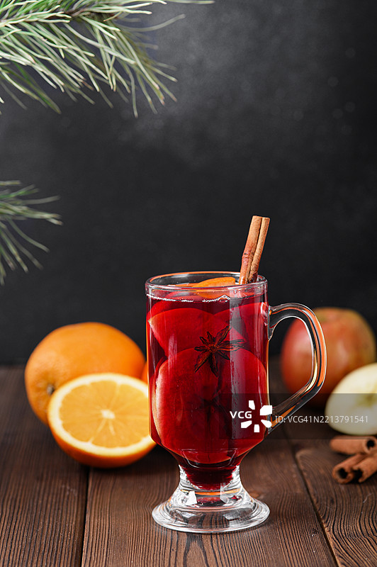 黑色背景上的热苹果肉桂香料酒玻璃杯图片素材