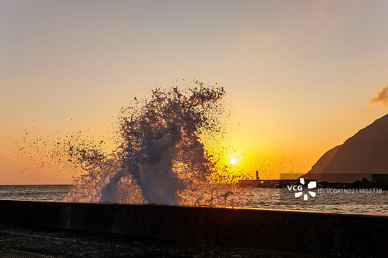 太平洋的汹涌波涛沐浴在八丈岛的晨光中。早晨在底港和底港海滩的日出。八丈岛，伊豆群岛，东京 - 2025年3月2日。图片素材
