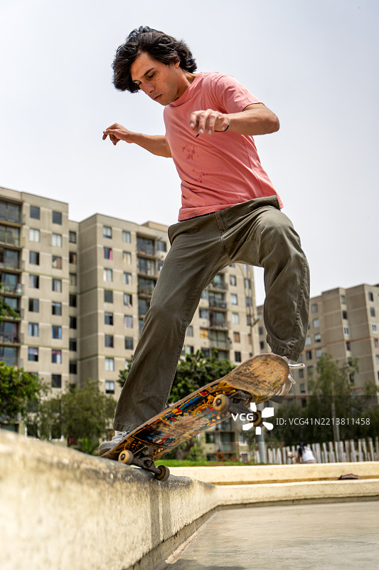 年轻滑板手在城市环境中表演特技图片素材