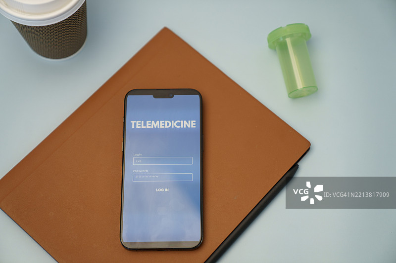 智能手机上显示的远程医疗登录界面，桌面上有相关物品图片素材