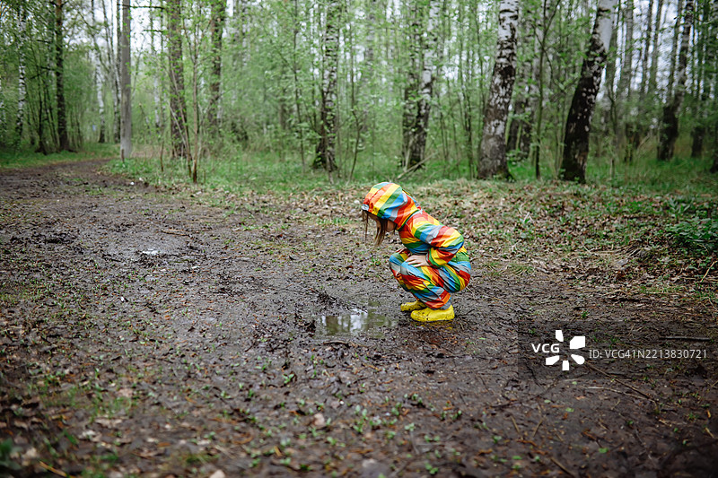 童年自由 - 孩子在泥水坑里踩水时欢笑图片素材
