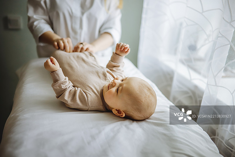 自然护理与真实育儿：女性在使用零废物尿布为婴儿换尿布。图片素材