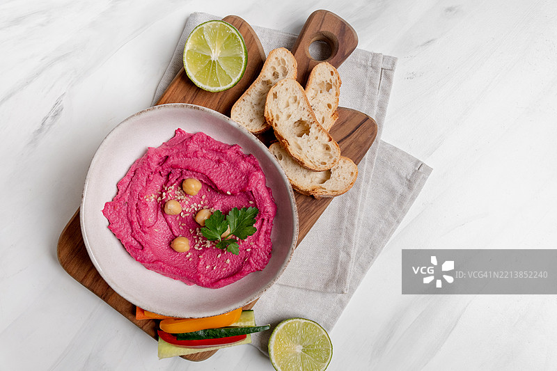 甜菜根粉红色鹰嘴豆酱涂抹酱，搭配鹰嘴豆和蔬菜的俯视图图片素材