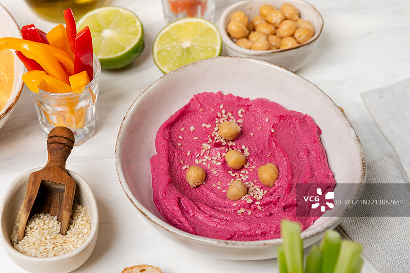 甜菜根粉红色鹰嘴豆酱涂抹酱，搭配鹰嘴豆和蔬菜的俯视图图片素材