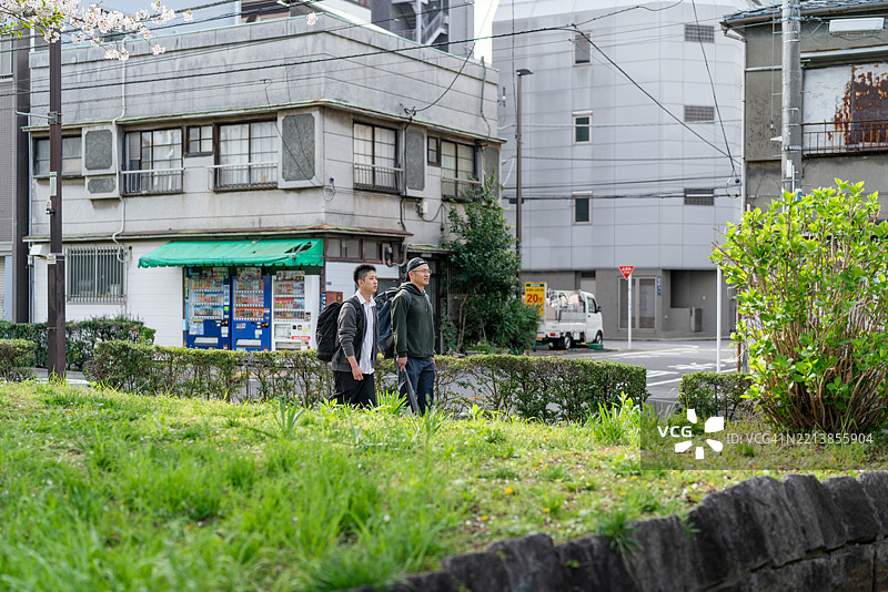 两个人在阳光明媚的东京街区散步图片素材