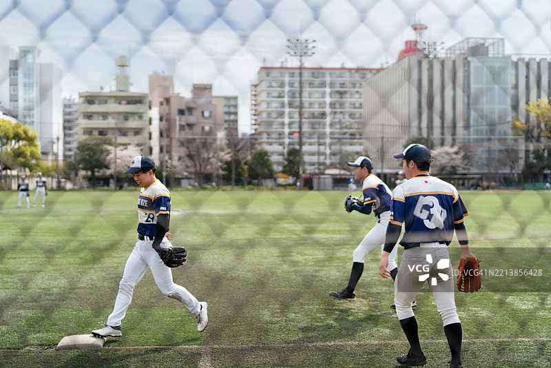 阳光明媚的棒球比赛，热情洋溢的队员们在运动中图片素材