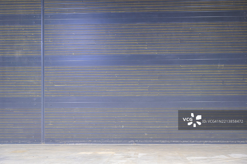 城市环境中白天的工业车库门，带有纹理表面和阴影。图片素材