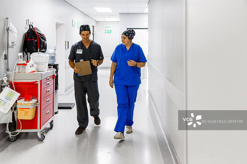 医生和护士在医院走廊里边走边讨论图片素材
