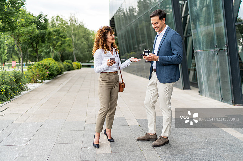 商务人士在办公楼外讨论工作图片素材