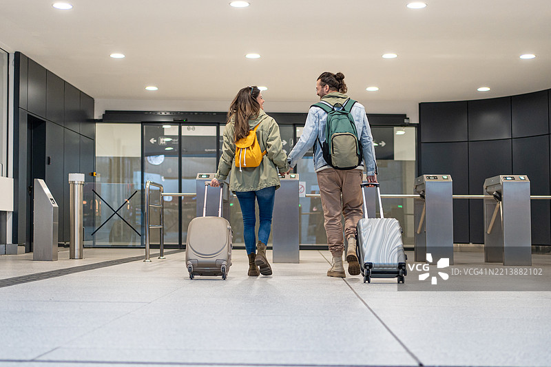 游客情侣在车站穿过旋转门图片素材