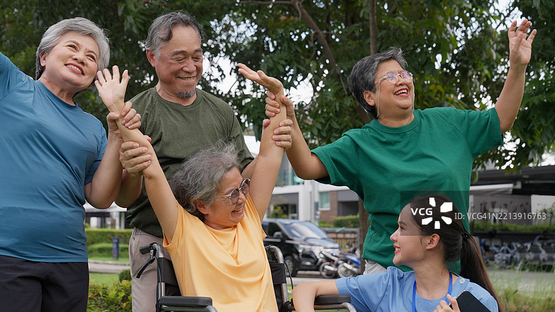 一群亚洲老年朋友在公园里放松娱乐，护士们给予鼓励。图片素材