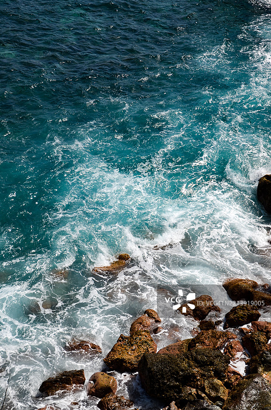 高角度拍摄的海浪拍打岩石图片素材