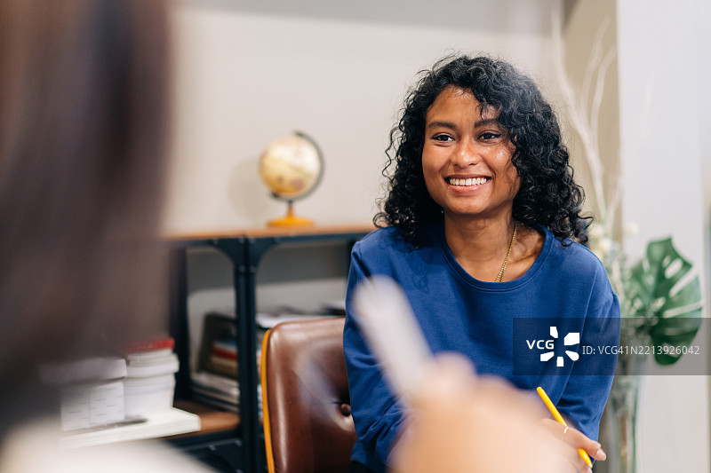 微笑的年轻女商人参与团队讨论图片素材