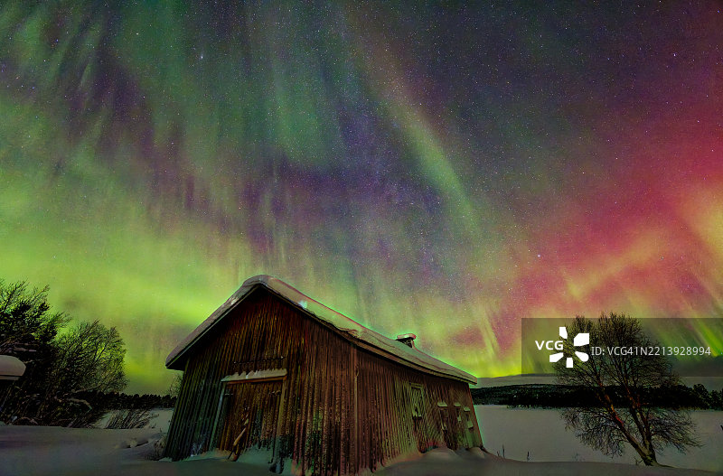 雪地中的小屋与北极光相映成趣图片素材