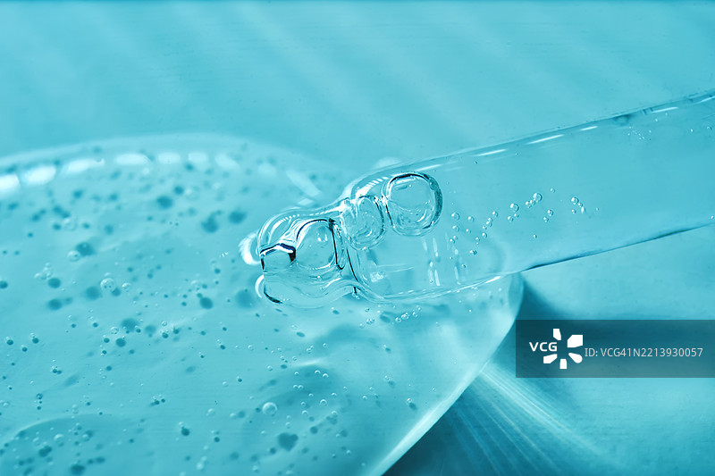 蓝色波纹背景上的移液管中的血清图片素材