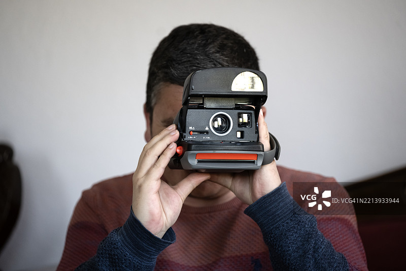 帅气的男人与即时相机图片素材