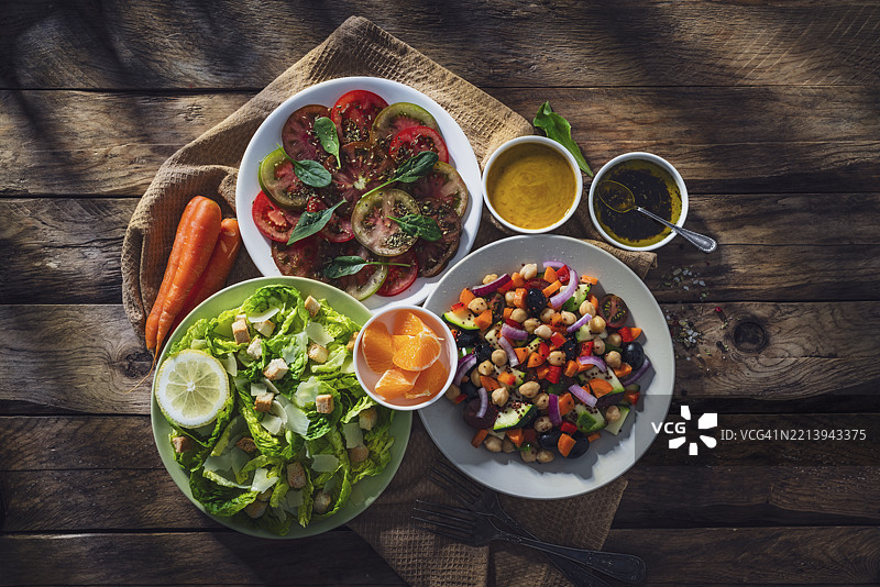 健康饮食与节食：三盘沙拉从上方拍摄，放在质朴的木桌上图片素材