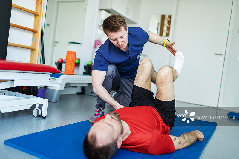 物理治疗专家与患者一起进行膝盖和背部的锻炼图片素材