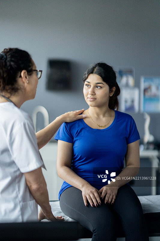 医疗专业人员在临床环境中为患者提供安慰和建议图片素材