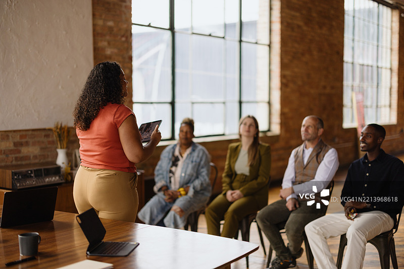 在现代办公室中，女商人使用平板电脑主持会议图片素材