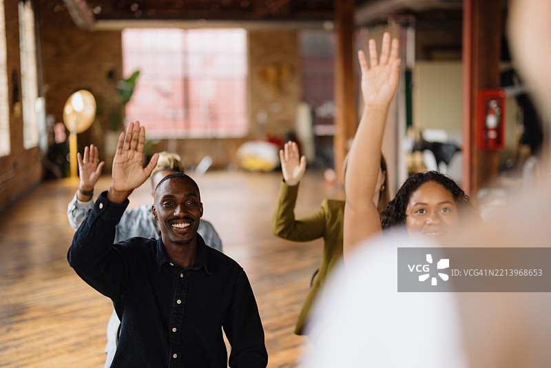 年轻专业人士在商务会议上举手图片素材