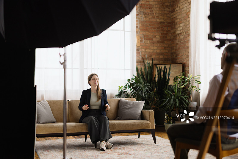 年轻女性在阁楼公寓接受记者采访图片素材