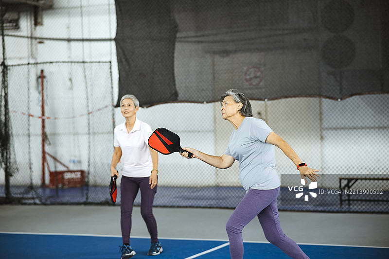 一起玩耍：年长的亚洲朋友们在乒乓球场上享受乐趣图片素材