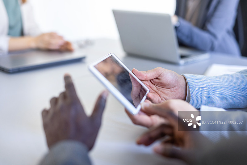 商务会议，桌上有数字设备和团队合作。图片素材
