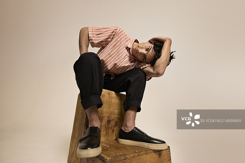 年轻男子坐在木凳上图片素材