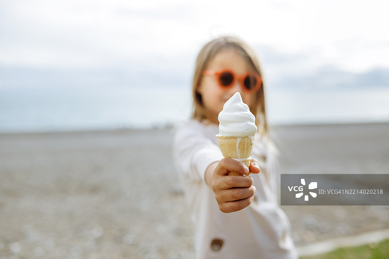 家庭日：海边戴着太阳镜的小孩和冰淇淋图片素材