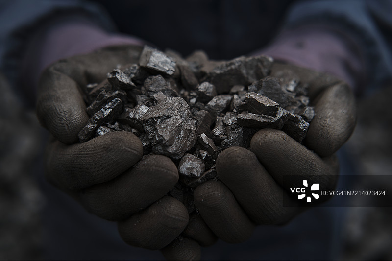 一个人手握一把焦煤图片素材